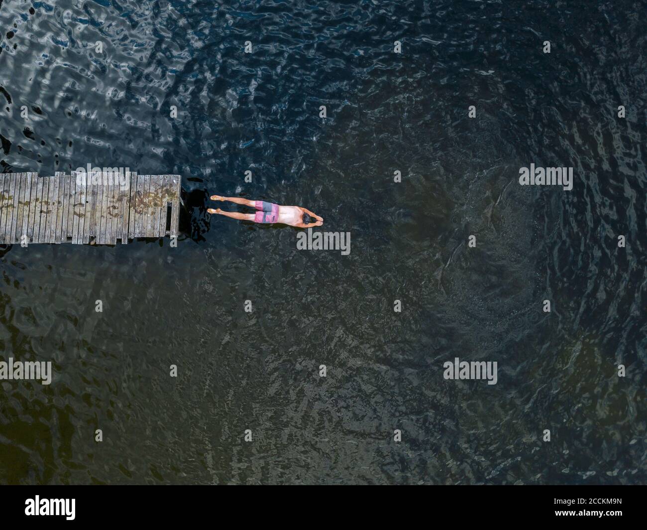 Vue aérienne de l'homme qui saute dans le lac Banque D'Images