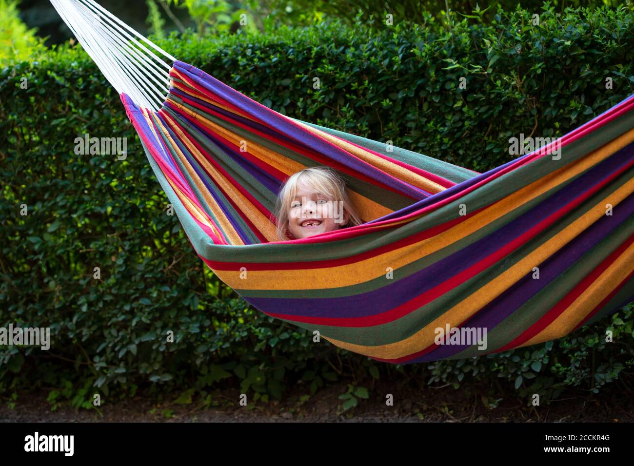 Jolie fille appréciant tout en étant allongé dans un hamac dans le jardin Banque D'Images