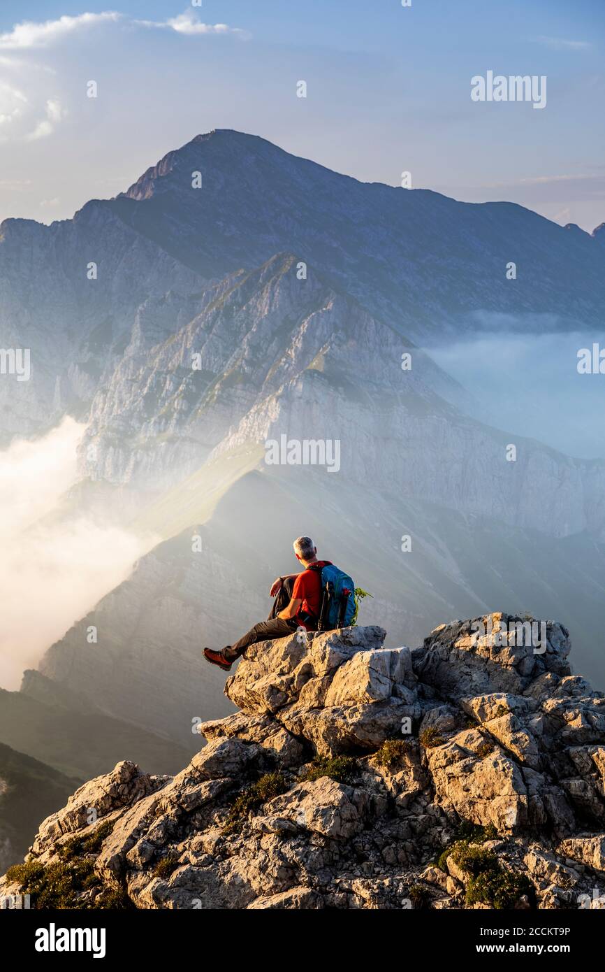 Homme assis au sommet du sommet de la montagne aux Alpes de Bergamasque, Italie Banque D'Images