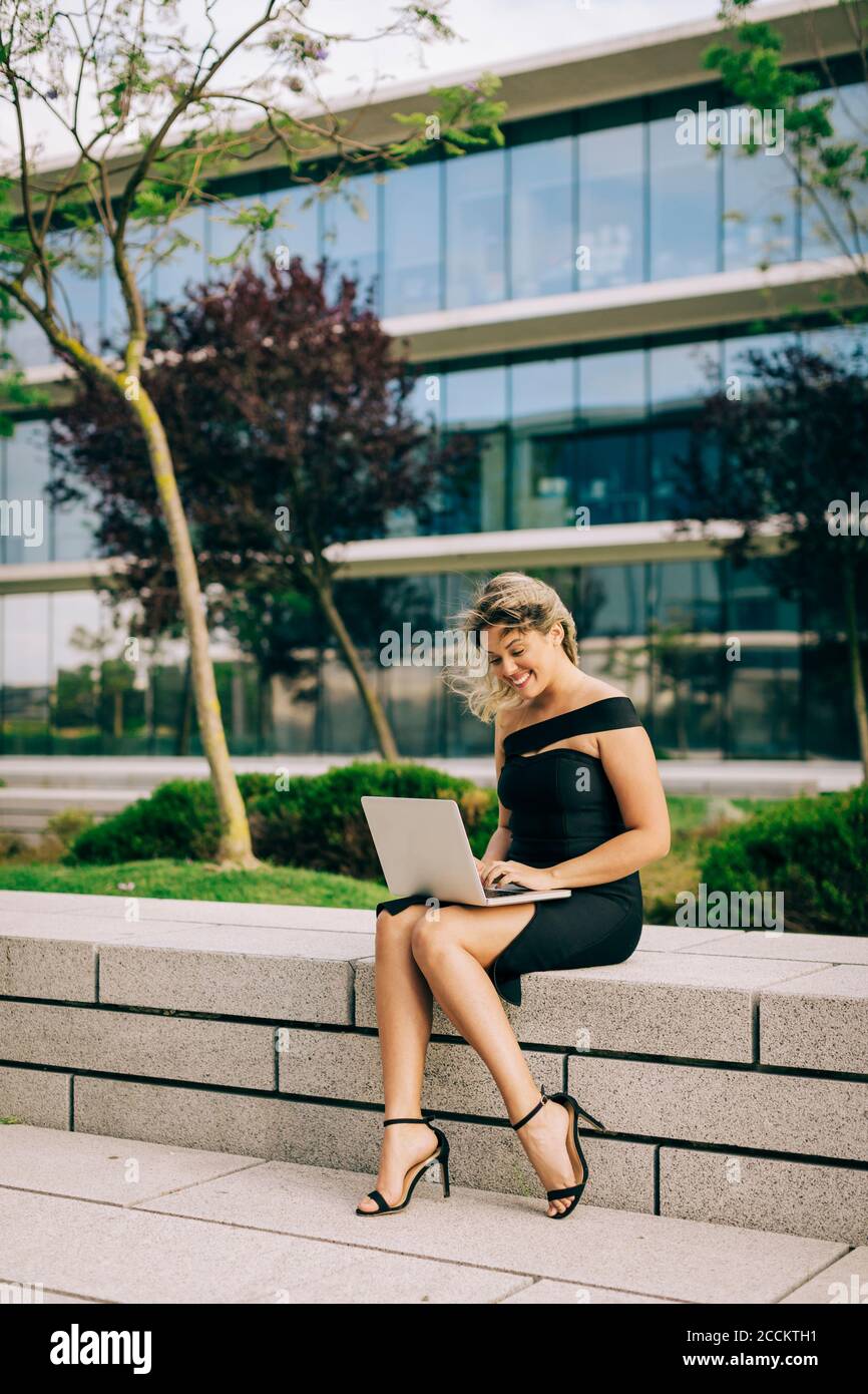 Businesswoman working on laptop outdoors Banque D'Images