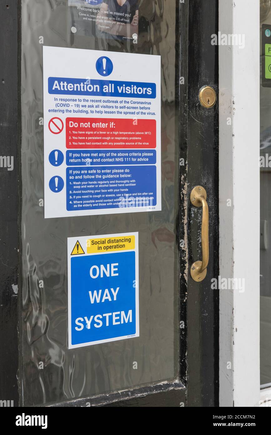 Nouvelles règles de sécurité pour les clients Pub au Royaume-Uni après le verrouillage Covid. Panneau sur la porte d'entrée du Globe Inn, Lostwithiel, avertissement de nouvelle routine. La Grande-Bretagne post-covid Banque D'Images
