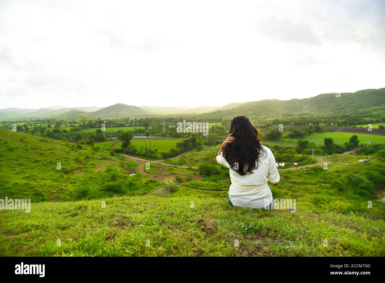 Jeunes femmes assis au sommet de la montagne et attendant le coucher du soleil. Concept de voyage . Banque D'Images