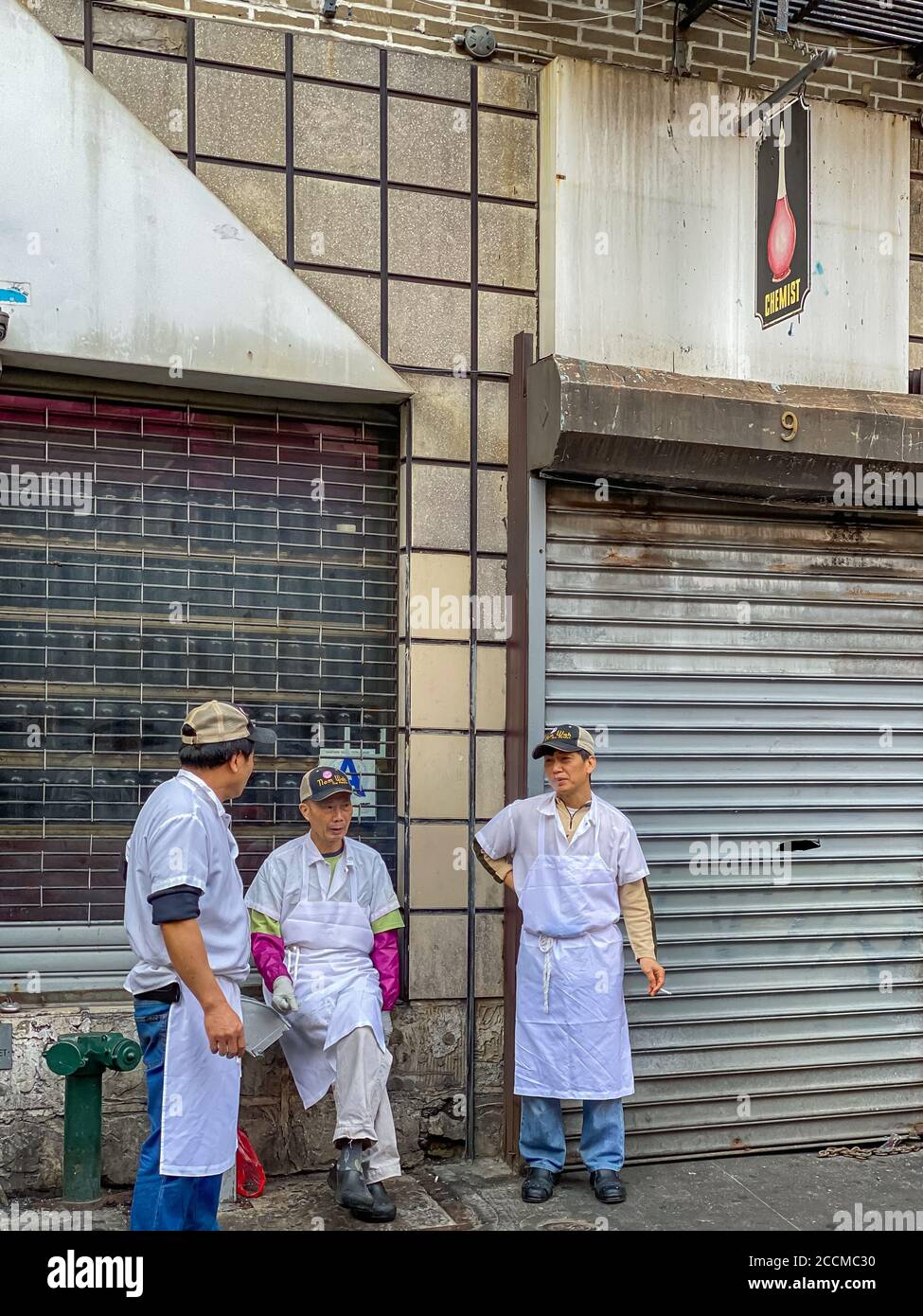 NEW YORK CITY, ÉTATS-UNIS - 27 décembre 2019 : les chefs font une pause-fumée à Doyers Street, Chinatown, New York City Banque D'Images