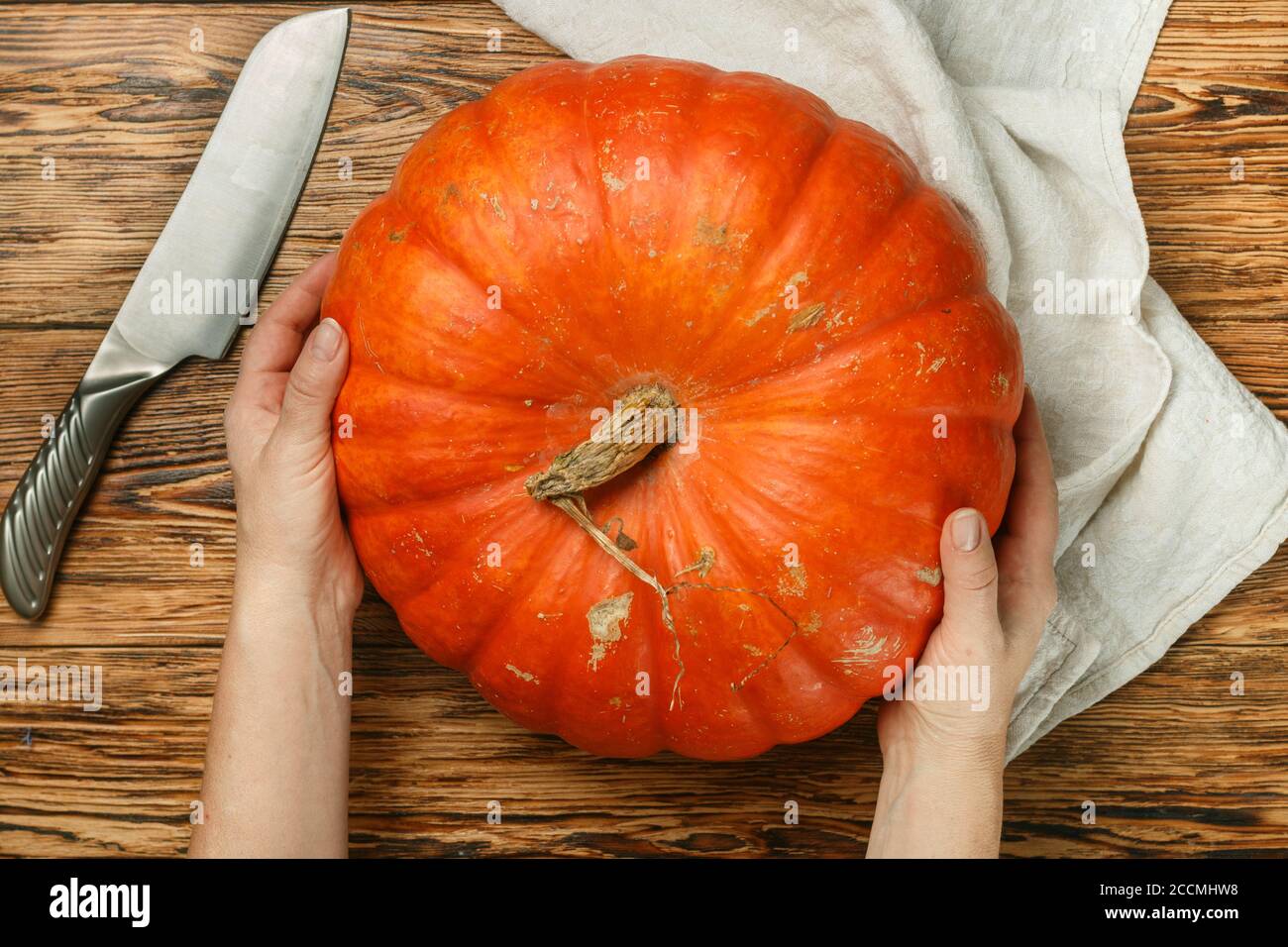 Femme tenant une grande citrouille biologique entière. Légumes sains et savoureux. Récolte du jardin. Symbole de Thanksgiving et Halloween. Foc sélectif Banque D'Images