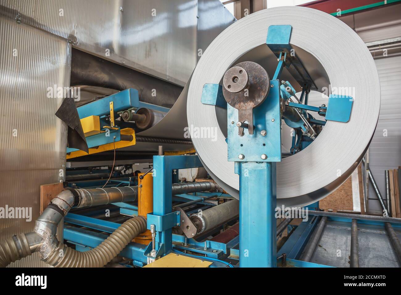 Rouleau en acier galvanisé dans la machine de formage de tôle dans l'usine de travail des métaux, gros plan. Banque D'Images