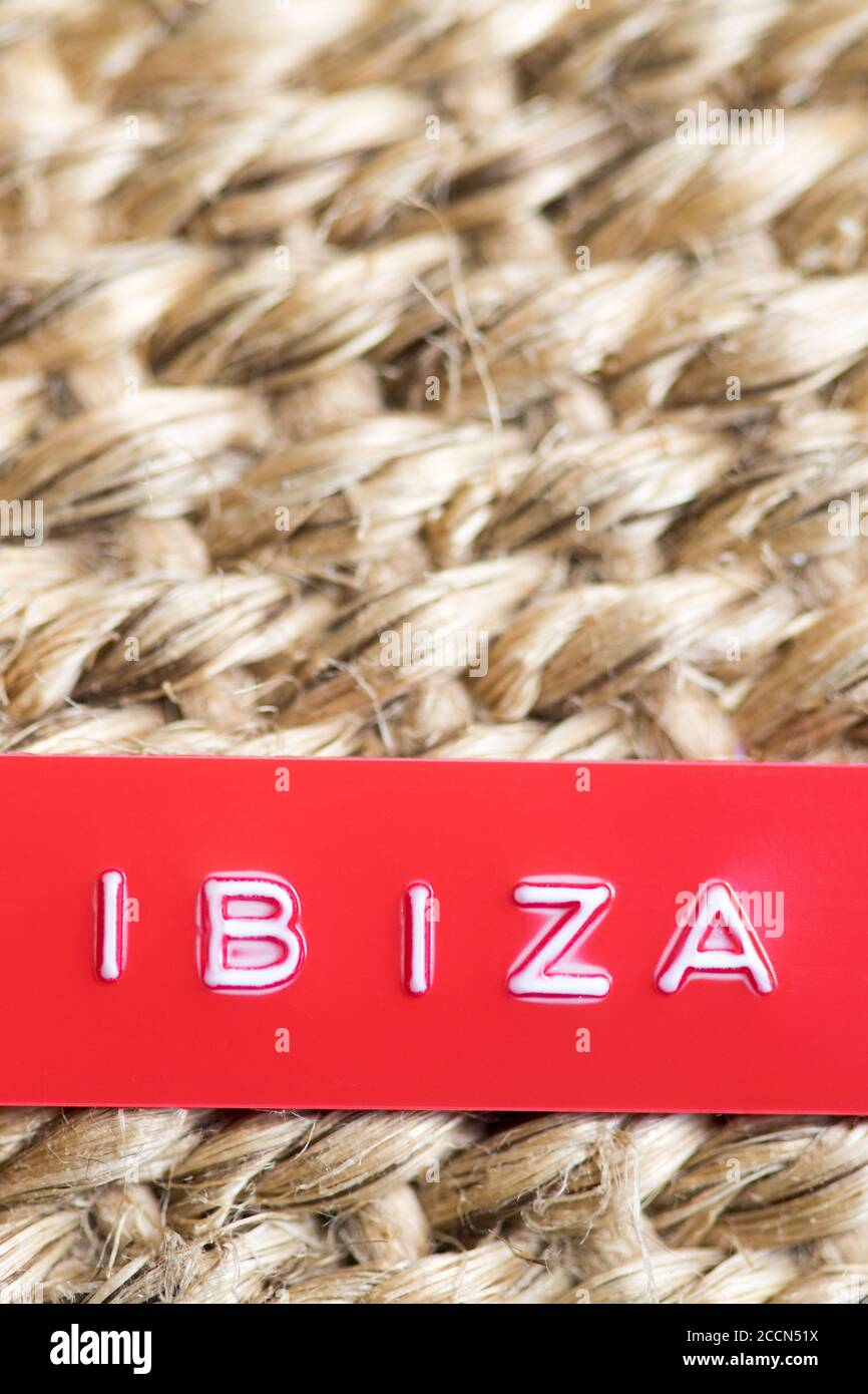 Étiquette rouge en relief avec les mots Ibiza sur une paille arrière-plan tissé Banque D'Images