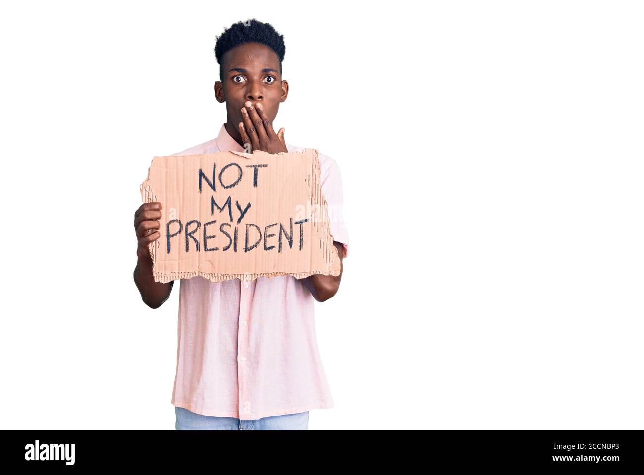 Un jeune afro-américain tenant pas la bannière de protestation de mon président qui couvre la bouche avec la main, choqué et peur de l'erreur. Expression surprise Banque D'Images