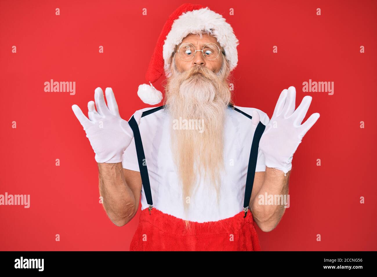 Homme âgé portant le costume du père noël avec des bretelles faisant le  visage de poisson avec la bouche et les yeux de boursoufrage, fou et  comique Photo Stock - Alamy