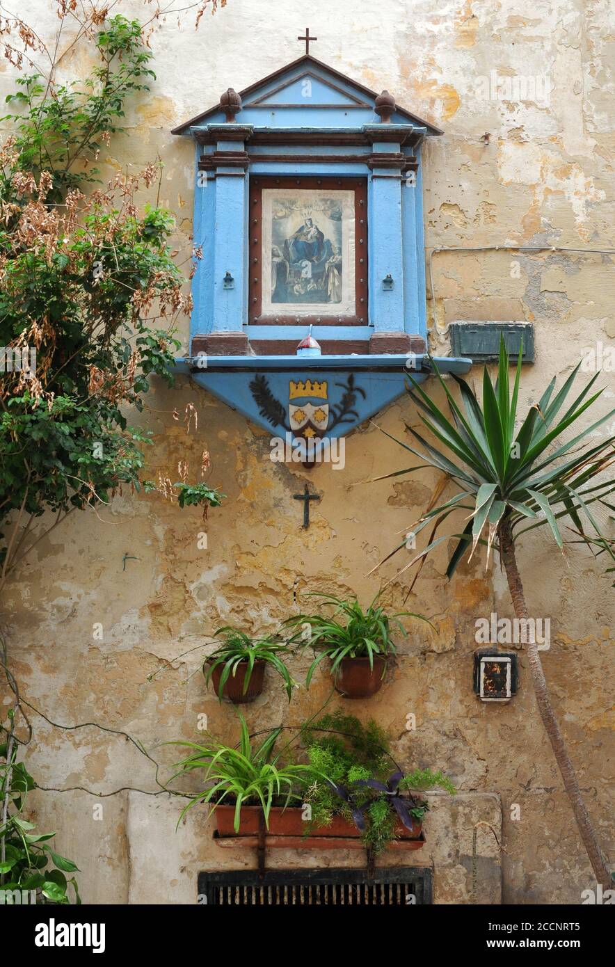 Un petit sanctuaire religieux monté sur le mur extérieur d'un bâtiment à la Valette, Malte. Banque D'Images