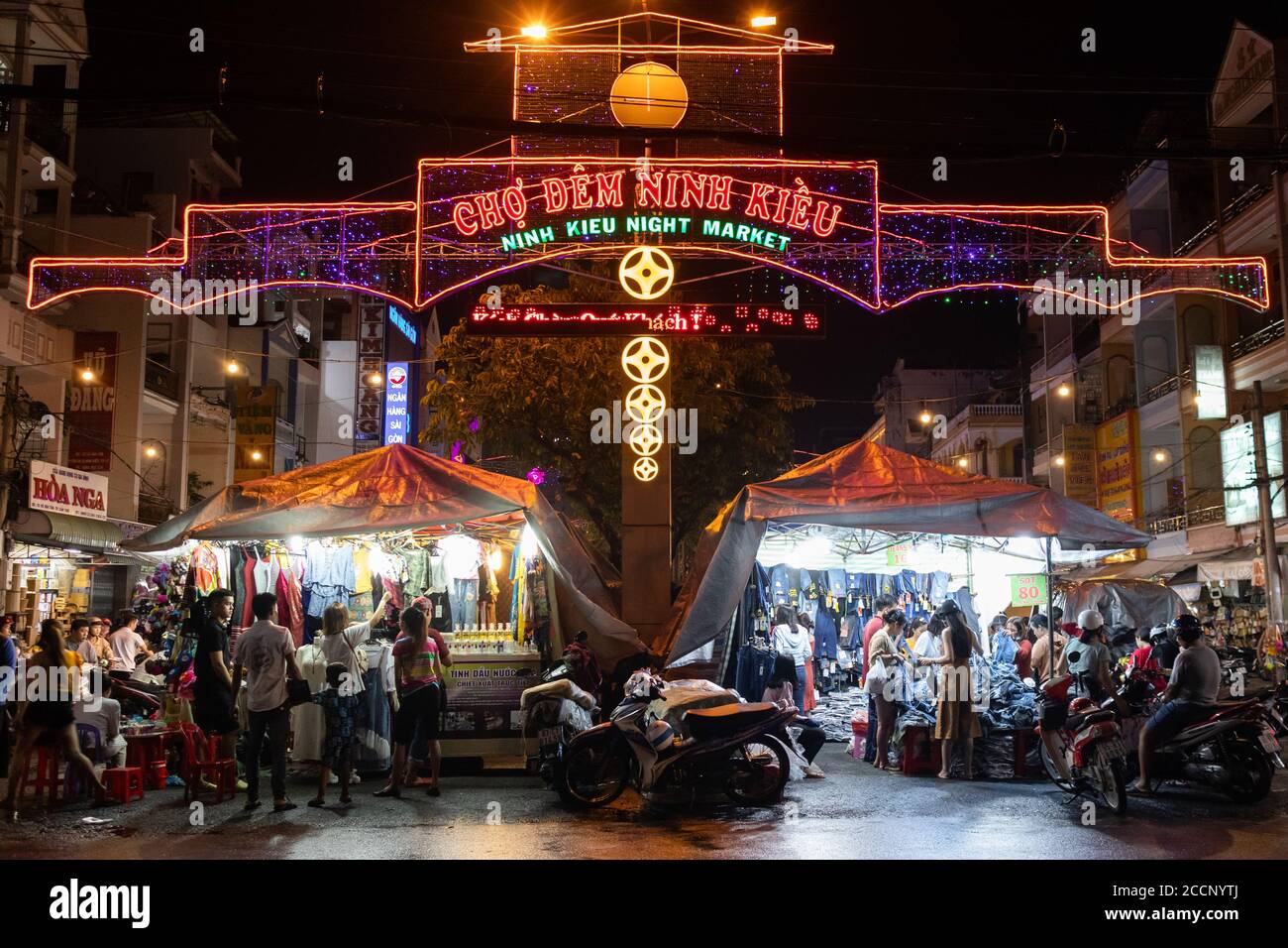 Marché de nuit en Asie. Personnes marchant ou en moto. Acheter des vêtements et de la nourriture. Pas de distance sociale avant Covid-19. Marché de Ninh Kieu, CAN Tho, Vietnam Banque D'Images