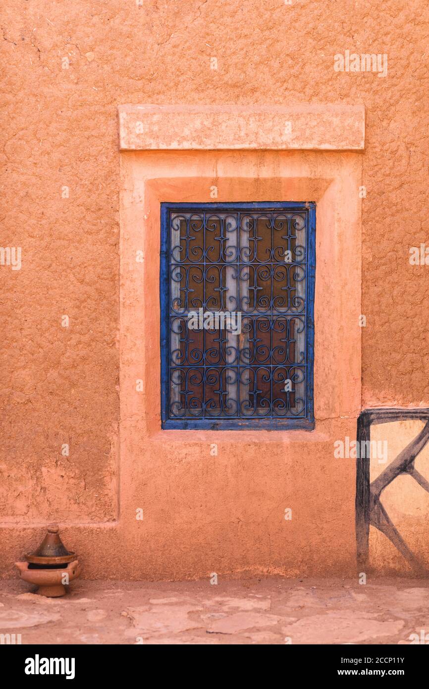 Fenêtre bleue fermée dans une maison marocaine traditionnelle avec mur de couleur rouge terre cuite. Style arabe dans l'architecture. Banque D'Images