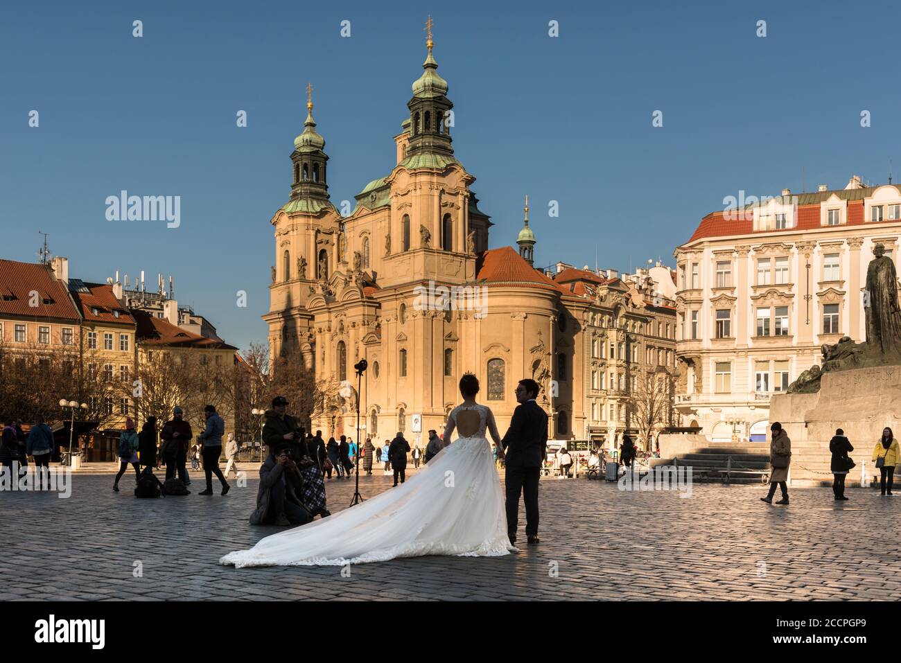 Mariée et marié posent pour un photographe de mariage dans la lumière tôt le matin, place de la Vieille ville, (Staromestske namesti), Stare Mesto, Prague. Banque D'Images