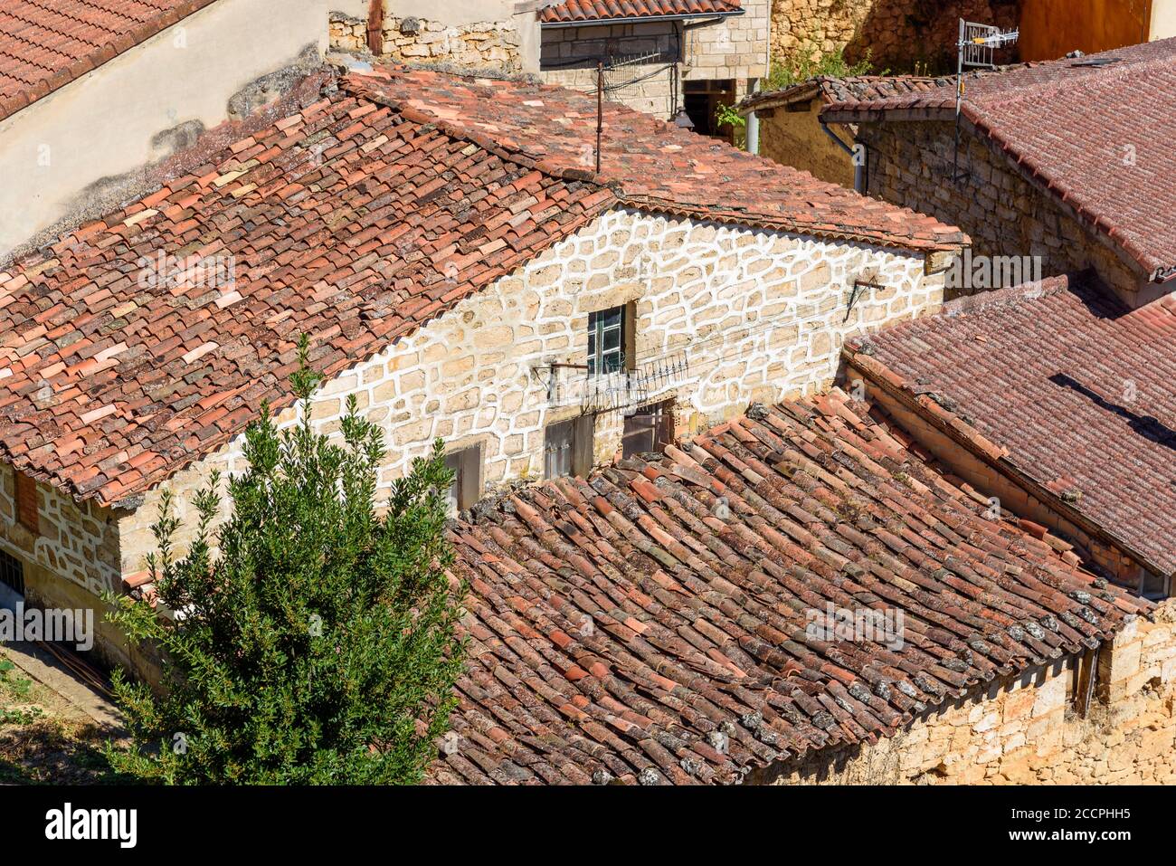 Arrière-plan de maisons de vieux village avec des murs en pierre et des toits de tuiles rouges. Banque D'Images