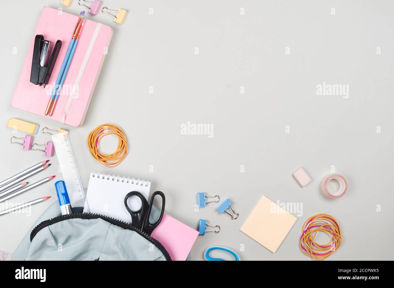 Fournitures scolaires différentes sur fond gris clair Banque D'Images