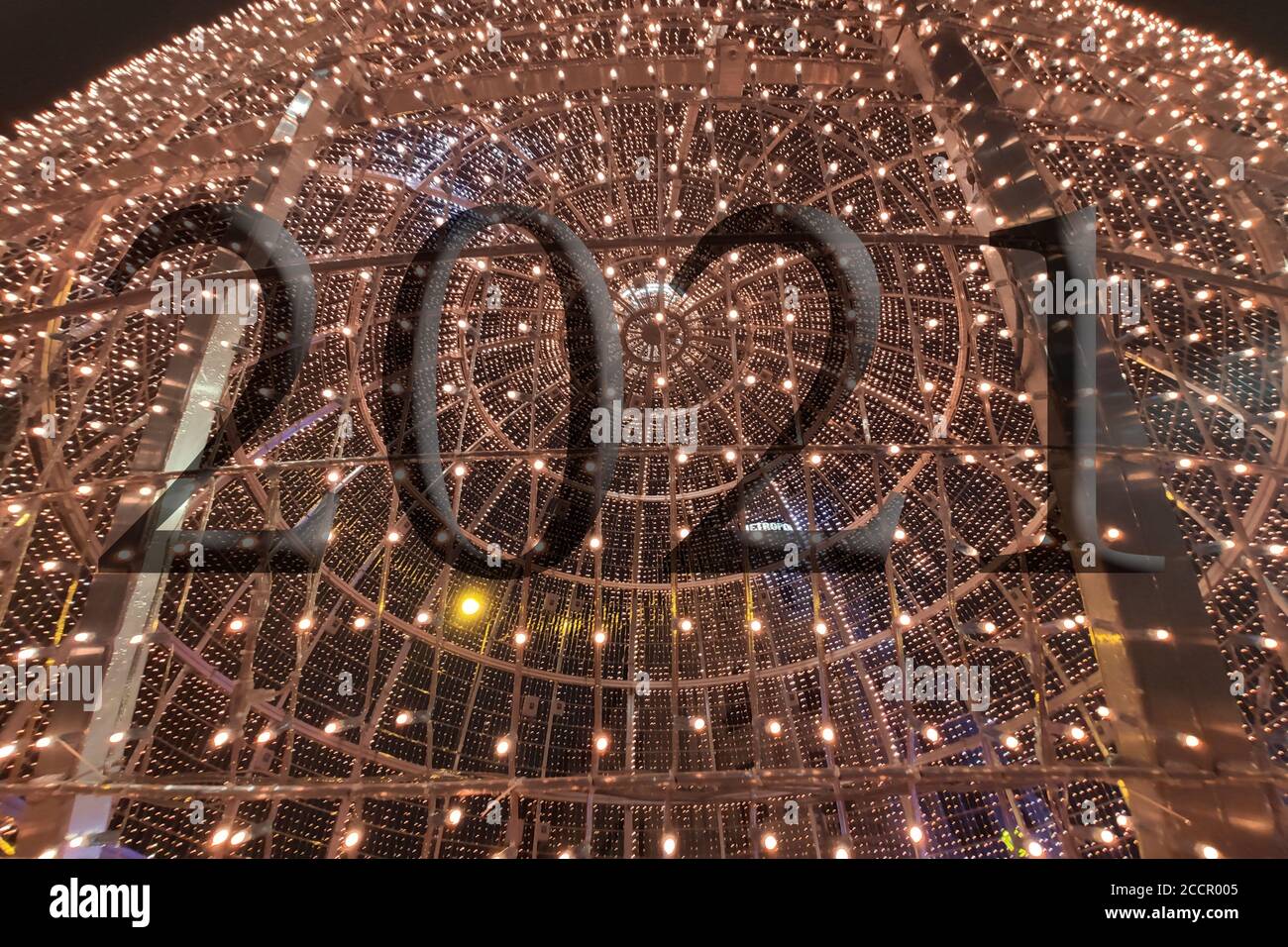Texte avec le numéro d'année 2021 avec un arrière-plan de lumières bleu clair hors de la mise au point avec effet bokeh. Bonne année 2021. Banque D'Images