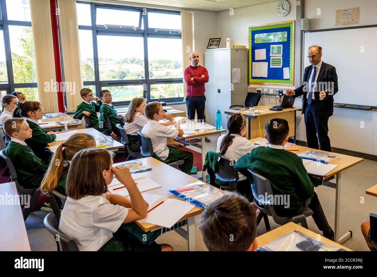 Peter Weir, ministre de l'éducation, parle avec les élèves de l'école primaire de St Joesph Carryduff, car les élèves de 7 ans sont autorisés à retourner à l'école en Irlande du Nord. Banque D'Images