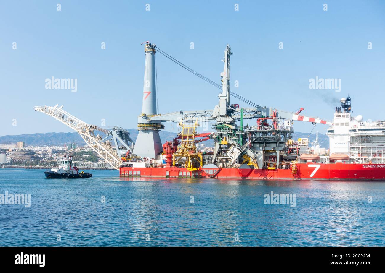 Pipelay de 182 mètres de long et navire de levage lourd, Seven Borialis, étant guidé hors du port de Las Palmas par des remorqueurs. Banque D'Images