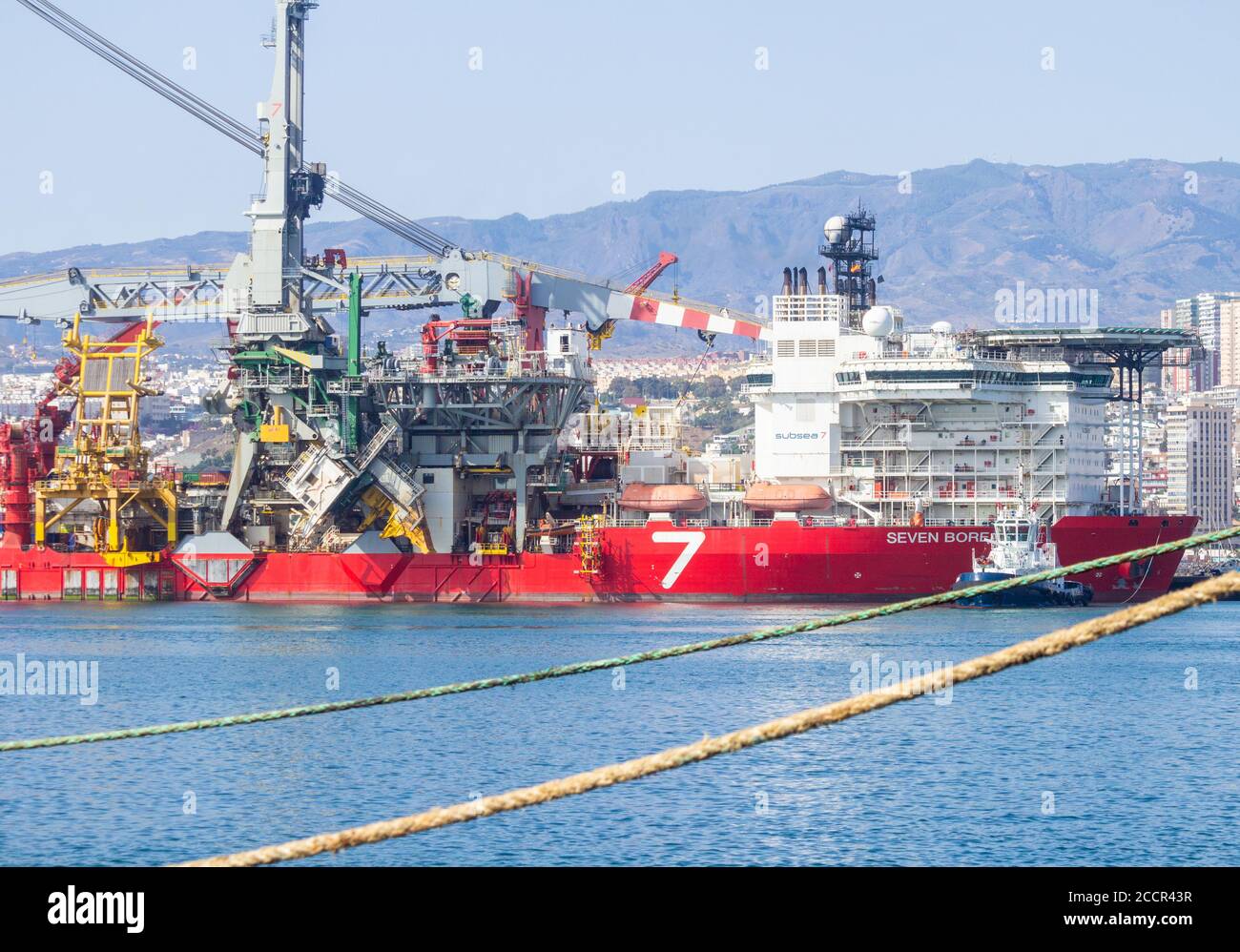 Pipelay de 182 mètres de long et navire de levage lourd, Seven Borialis, étant guidé hors du port de Las Palmas par des remorqueurs. Banque D'Images