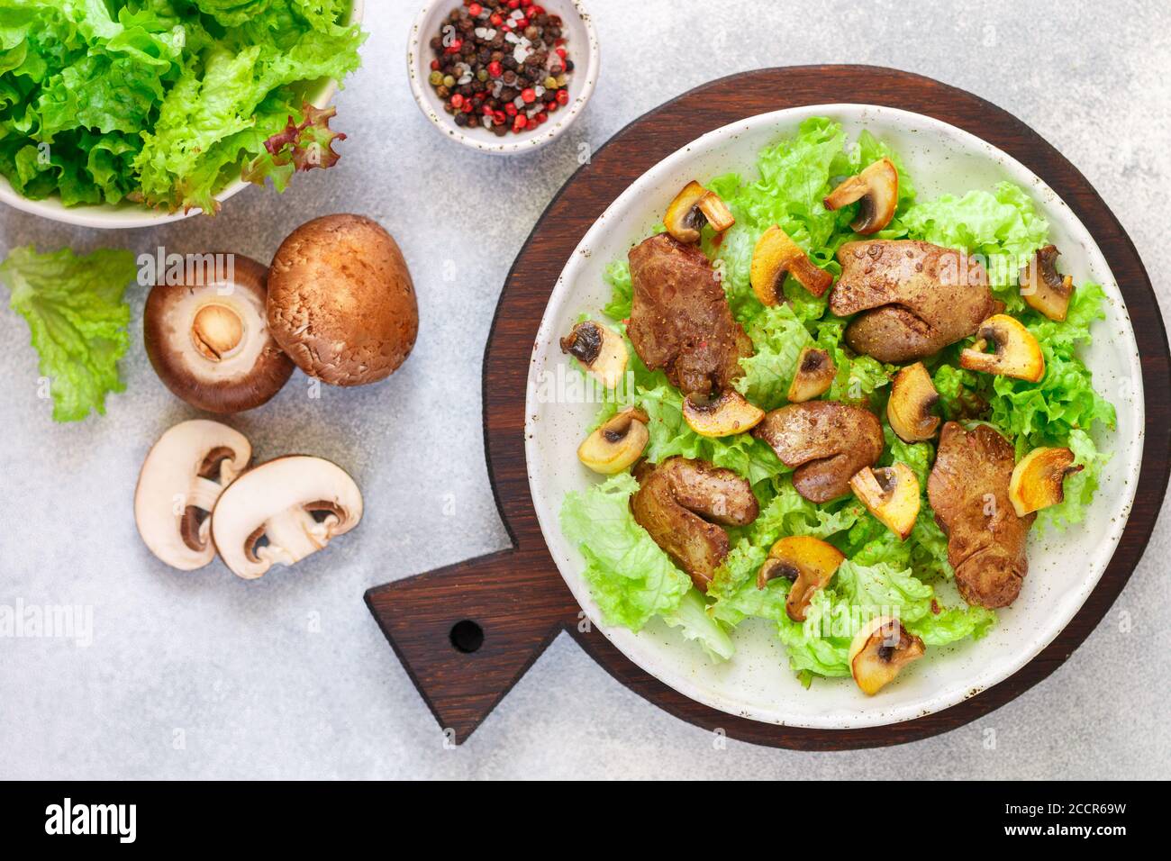 Salade de laitue chaude avec foie de poulet, champignons frits, huile d'olive, assaisonnements et balsamique. Délicieux dîner gastronomique. Mise au point sélective Banque D'Images