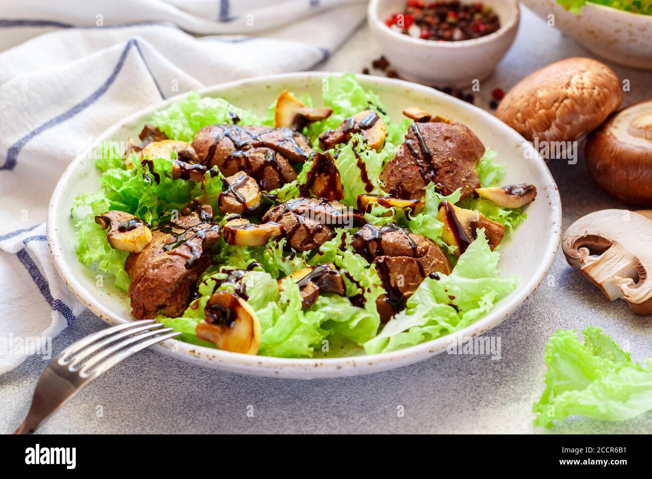 Salade de laitue chaude avec foie de poulet, champignons frits, huile d'olive, assaisonnements et balsamique. Délicieux dîner gastronomique. Mise au point sélective Banque D'Images