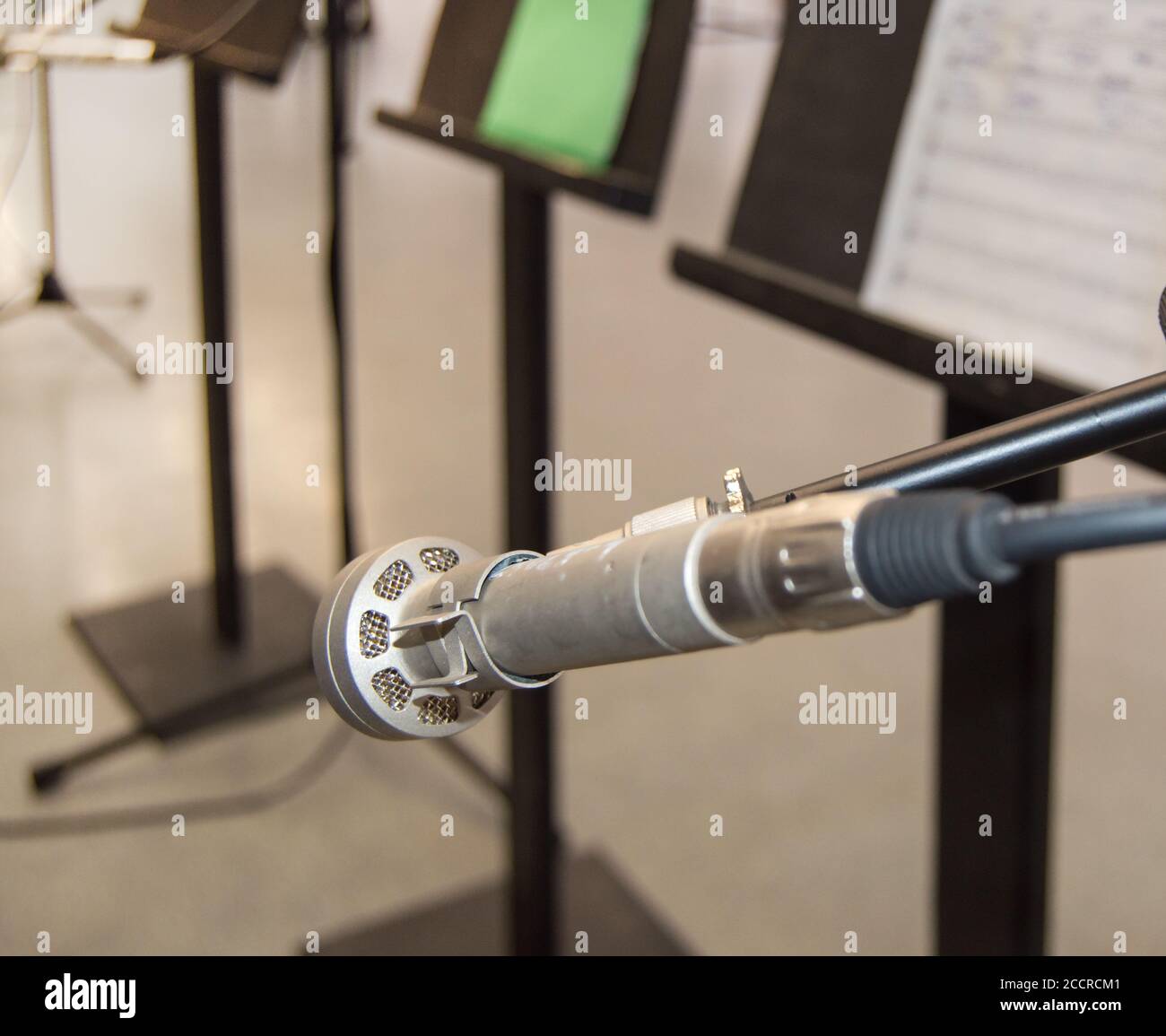 Microphone et notes de musique sur un support de musique sur un fond flou, DOF, vue latérale. Banque D'Images