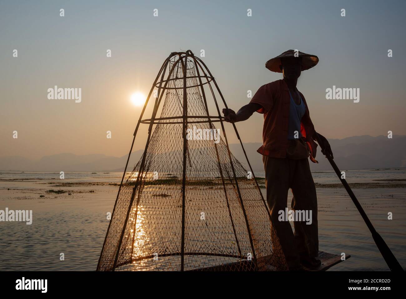 Intha pêcheur traditionnel d'aviron de jambe sur le lac Inle au coucher du soleil, Birmanie, Myanmar Banque D'Images
