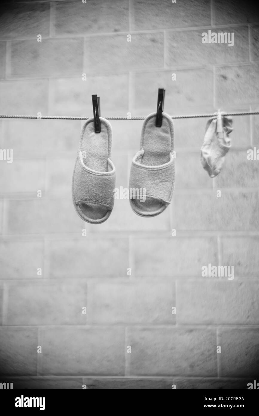 Les chaussons et chaussettes femelles sont séchés sur une corde à linge en été. PHOTO BW. Banque D'Images