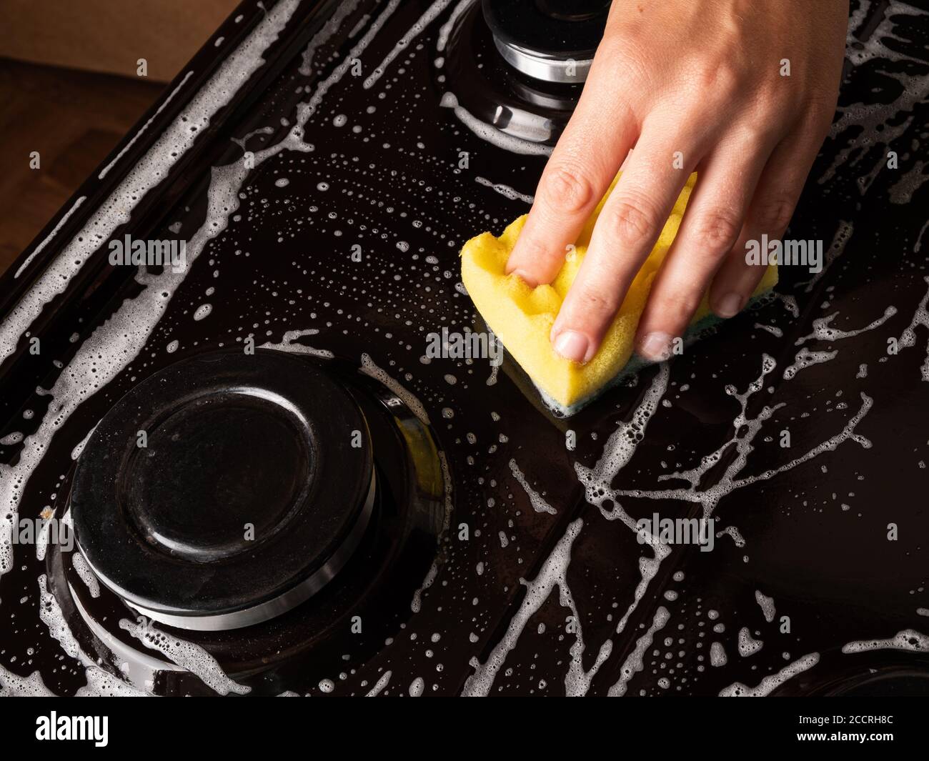 nettoyage de la cuisine, nettoyage de la surface de la cuisinière à gaz avec un débarbouillette, appareils électroménagers. Banque D'Images