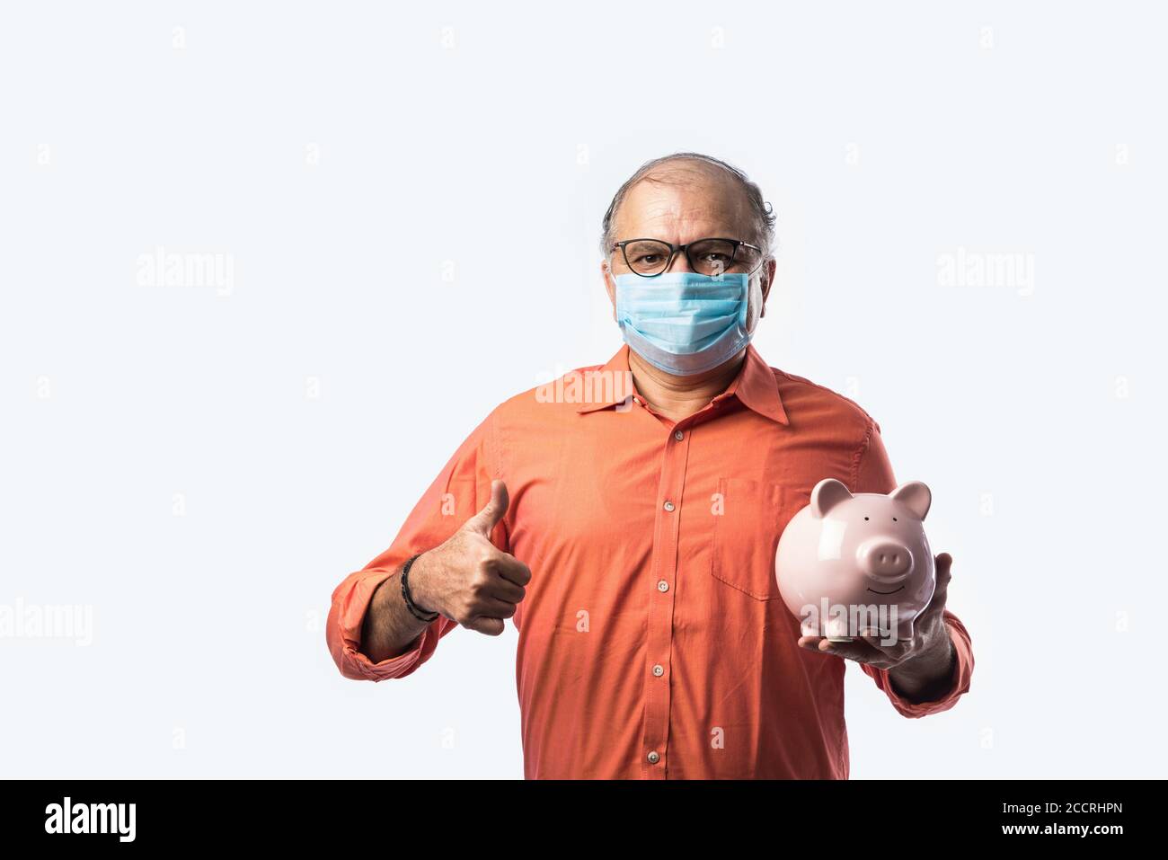 Indien senior adulte ou vieux avec le masque de maintien banque de porc ou caisse Banque D'Images