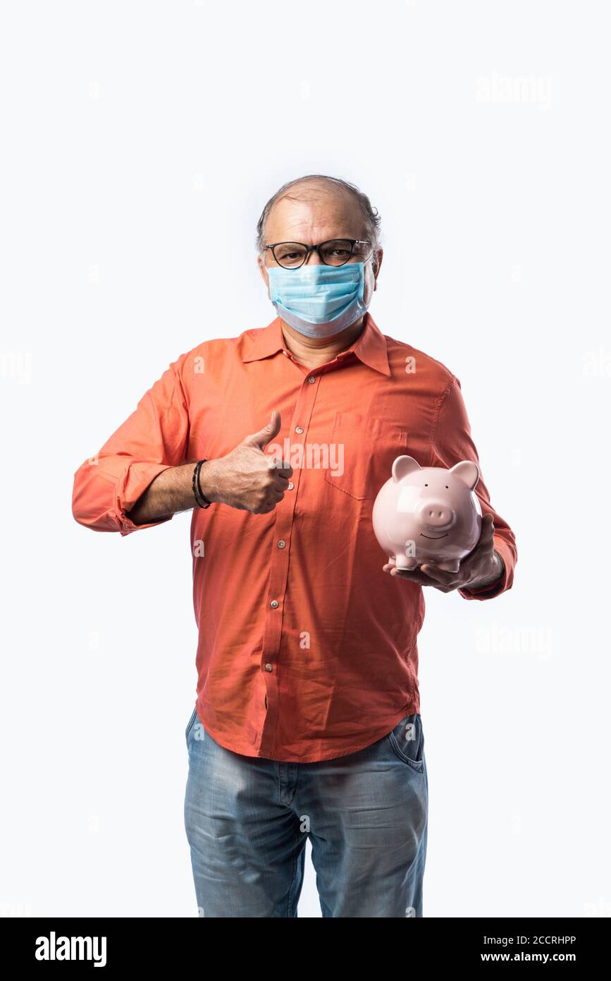 Indien senior adulte ou vieux avec le masque de maintien banque de porc ou caisse Banque D'Images
