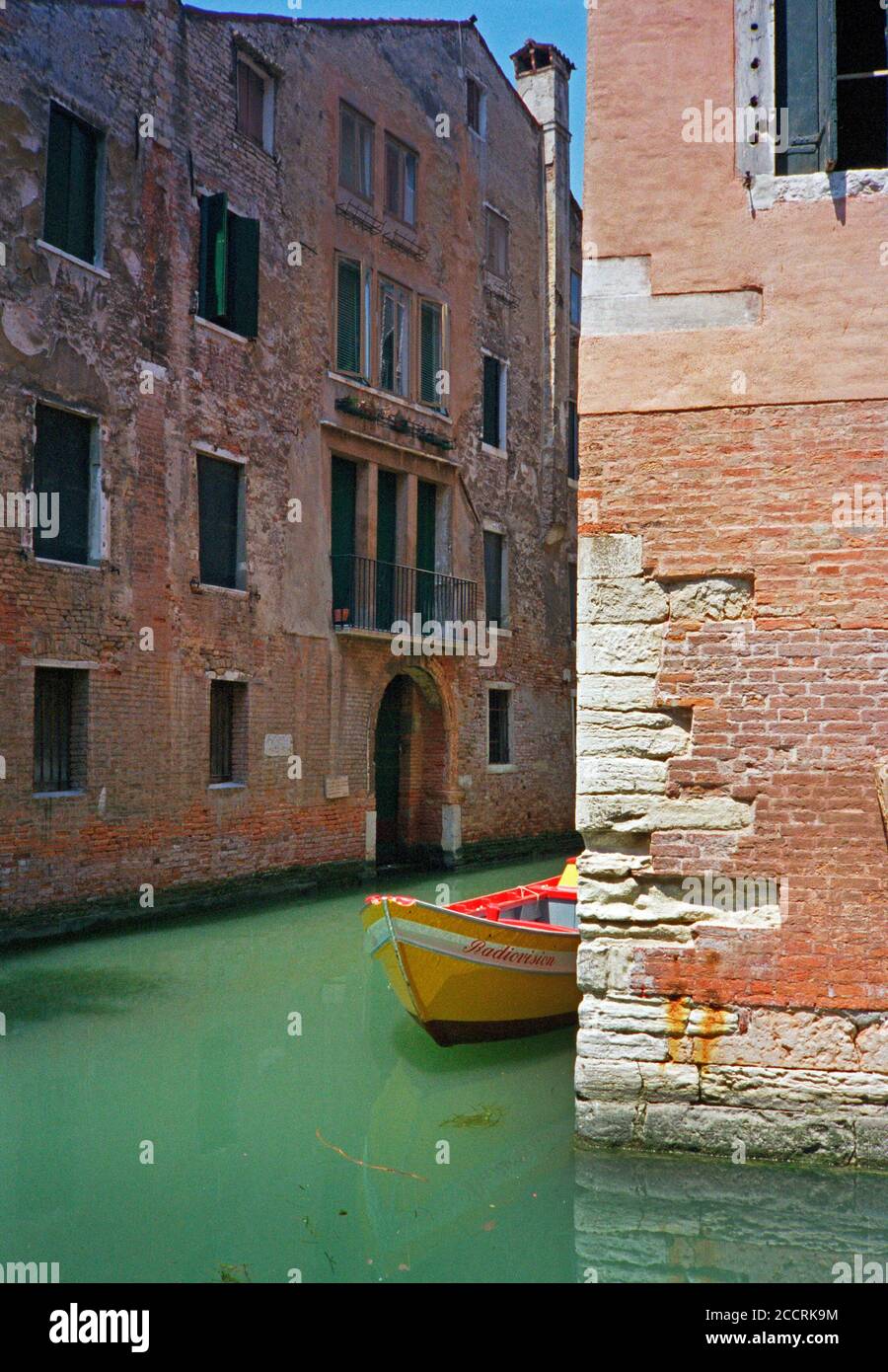 Un bateau coloré amarré dans l'un des canaux de Venise. Italie. Banque D'Images