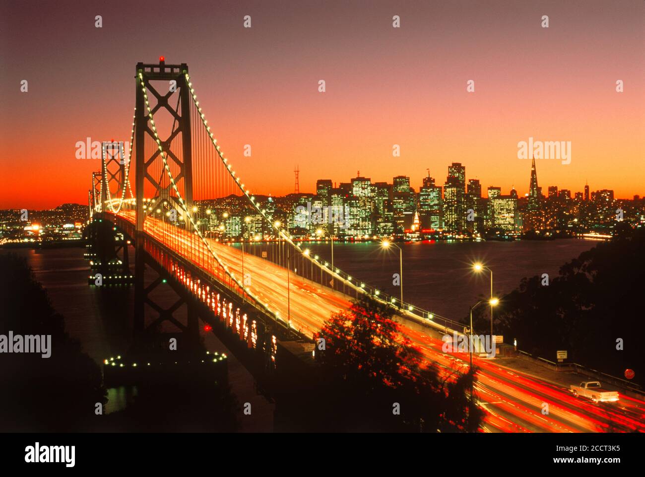 Oakland Bay Bridge vers San Francisco au crépuscule avec diffusion en continu trafic Banque D'Images