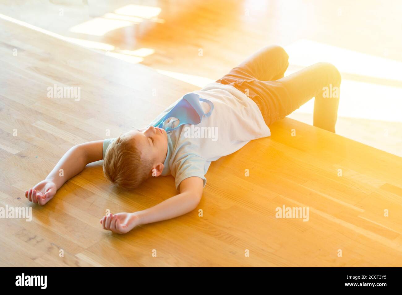 Enfant fatigué stressé épuisé avec masque bleu dans une leçon. Retour à l'école en toute sécurité pendant la pandémie concept. Distance sociale pour combattre COVID-19 Banque D'Images