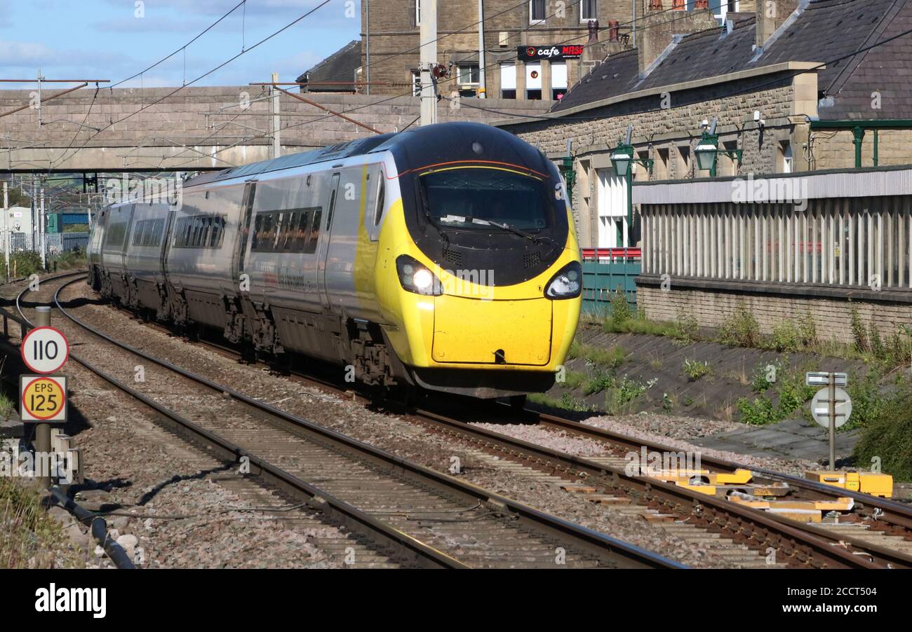 Avanti pendolino Electric train, West Coast main Line, Carnforth avec une décoration spéciale de masque et de message de couleur jaune les voyages sûrs portent une couverture de visage. Banque D'Images