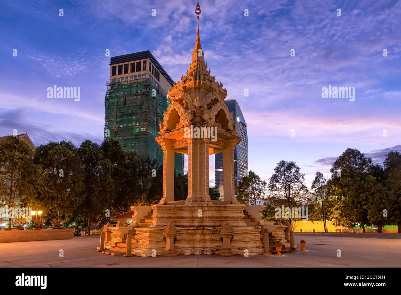 La statue de Yeay Penh près de Wat Phnom Penh, au Cambodge, avec des appartements en hauteur derrière Banque D'Images