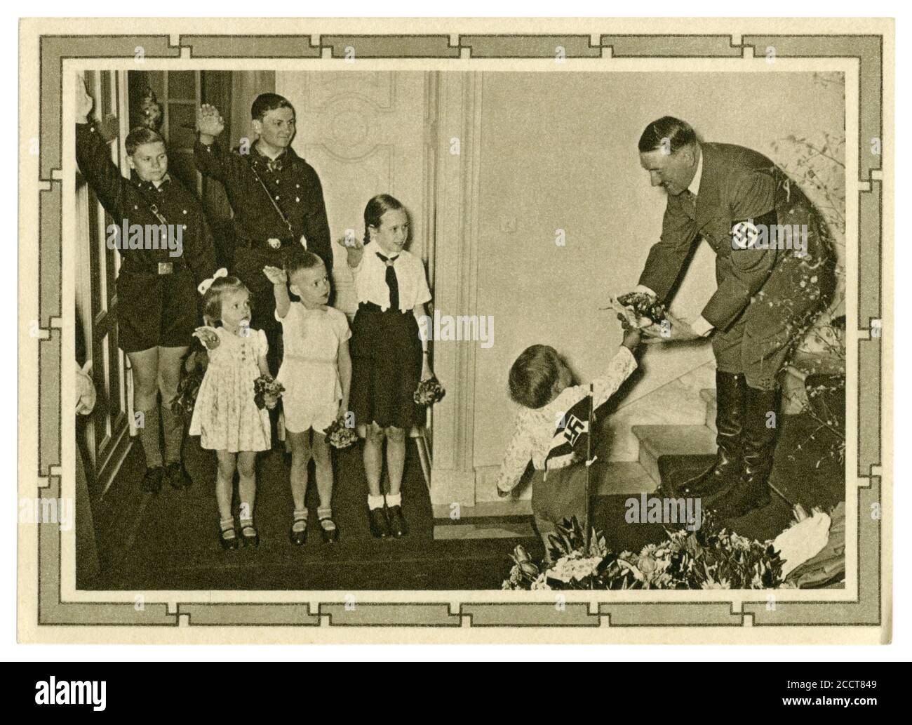 Carte postale historique allemande : 50e anniversaire d'Adolf Hitler. Il reçoit un bouquet de fleurs du plus jeune des 6 enfants de Goebbels, Allemagne, 1939 Banque D'Images