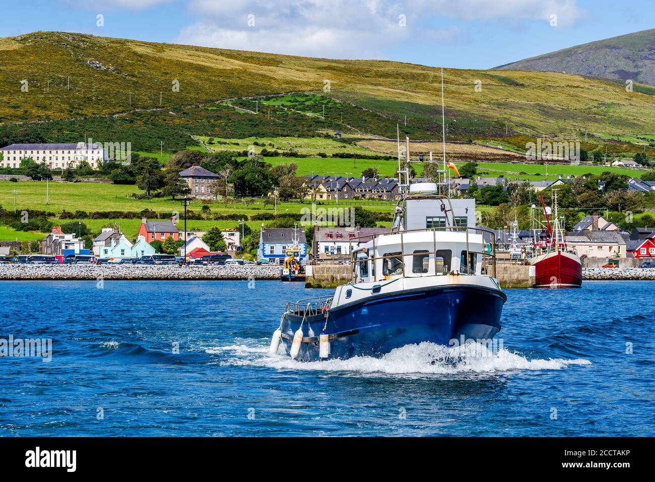 Excursion en bateau au départ du port de Dingle pour visiter et observer les dauphins de Fungie avec le village de Dingle en arrière-plan. Co Kerry, Irlande Banque D'Images