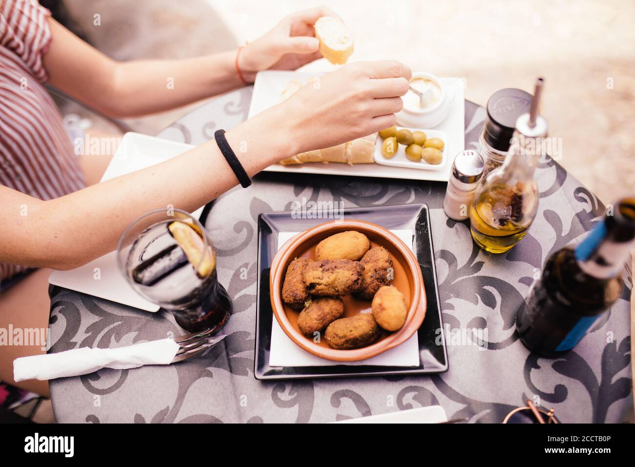 Femme mangeant de la nourriture typiquement espagnole. Croquettes olives et sauce à l'ail Banque D'Images