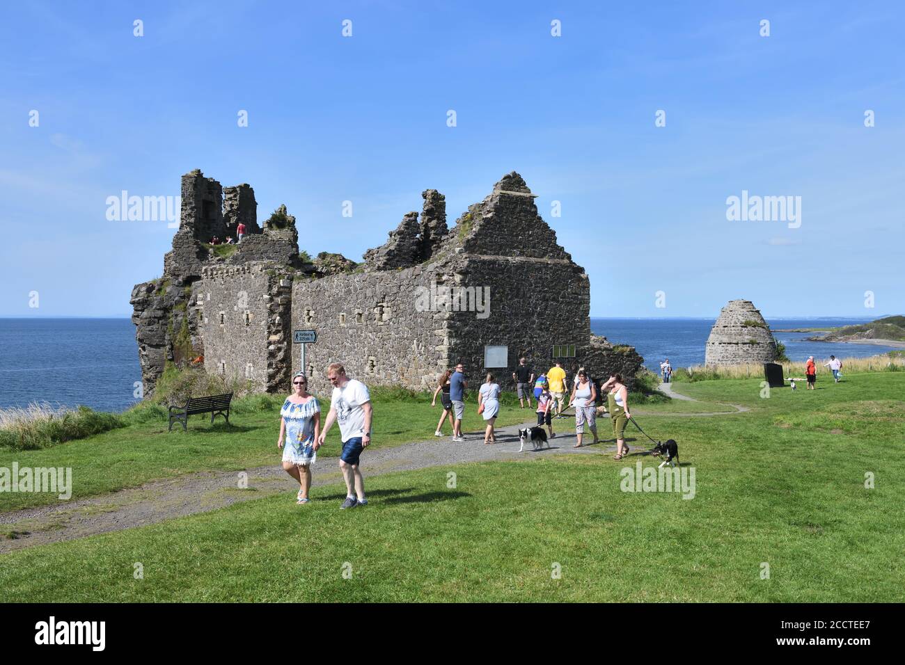 Les gens profitent d'une journée chaude et ensoleillée en se rendant au château de Dunure construit au XIIIe siècle sur le Firth of Clyde, Ayrshire, Écosse, Royaume-Uni, Europe Banque D'Images