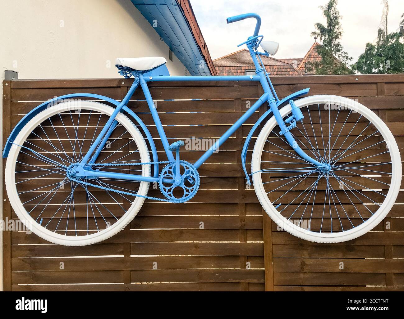 Vélo bleu suspendu sur la clôture. Décoration spéciale. Banque D'Images