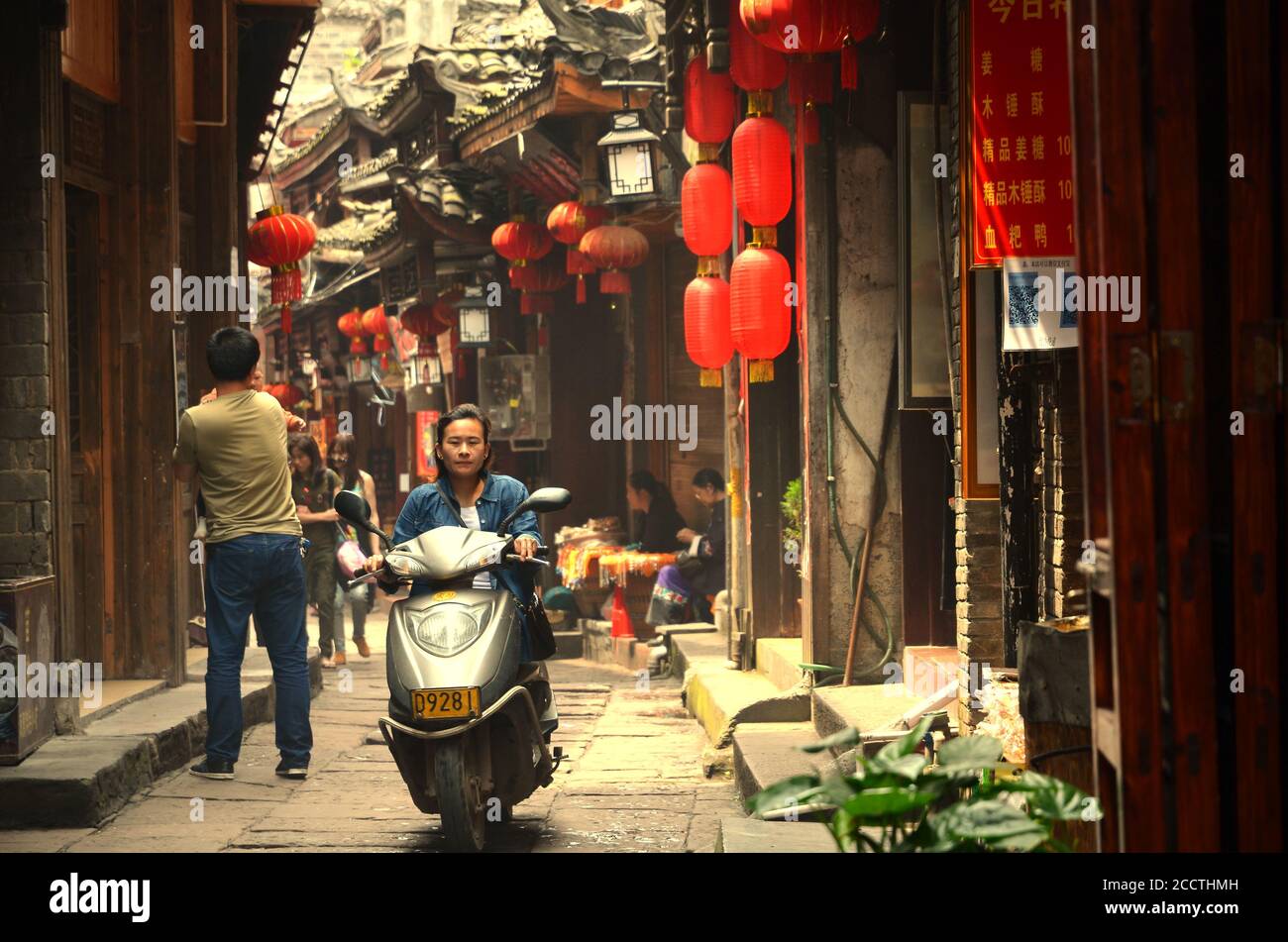 Fenghuang, Chine - 15 mai 2017 : femme à moto dans la rue de Phoenix Fenghuang City Banque D'Images