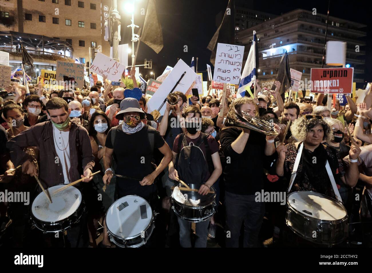 Des manifestants tiennent des pancartes et battent des tambours lors d'une manifestation de masse à laquelle ont assisté plus de 10000 personnes dans le cadre de manifestations en cours contre le Premier ministre Benjamin Netanyahu au sujet de son inculpation pour corruption et manipulation de la pandémie du coronavirus près de la résidence officielle du Premier ministre le 22 août 2020 à Jérusalem, Israël Banque D'Images