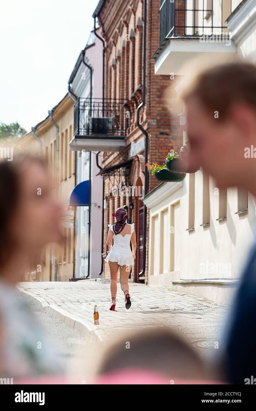 Une femme dans une robe très courte marche dans la rue, photographiée à  travers des gens flous en premier plan Photo Stock - Alamy