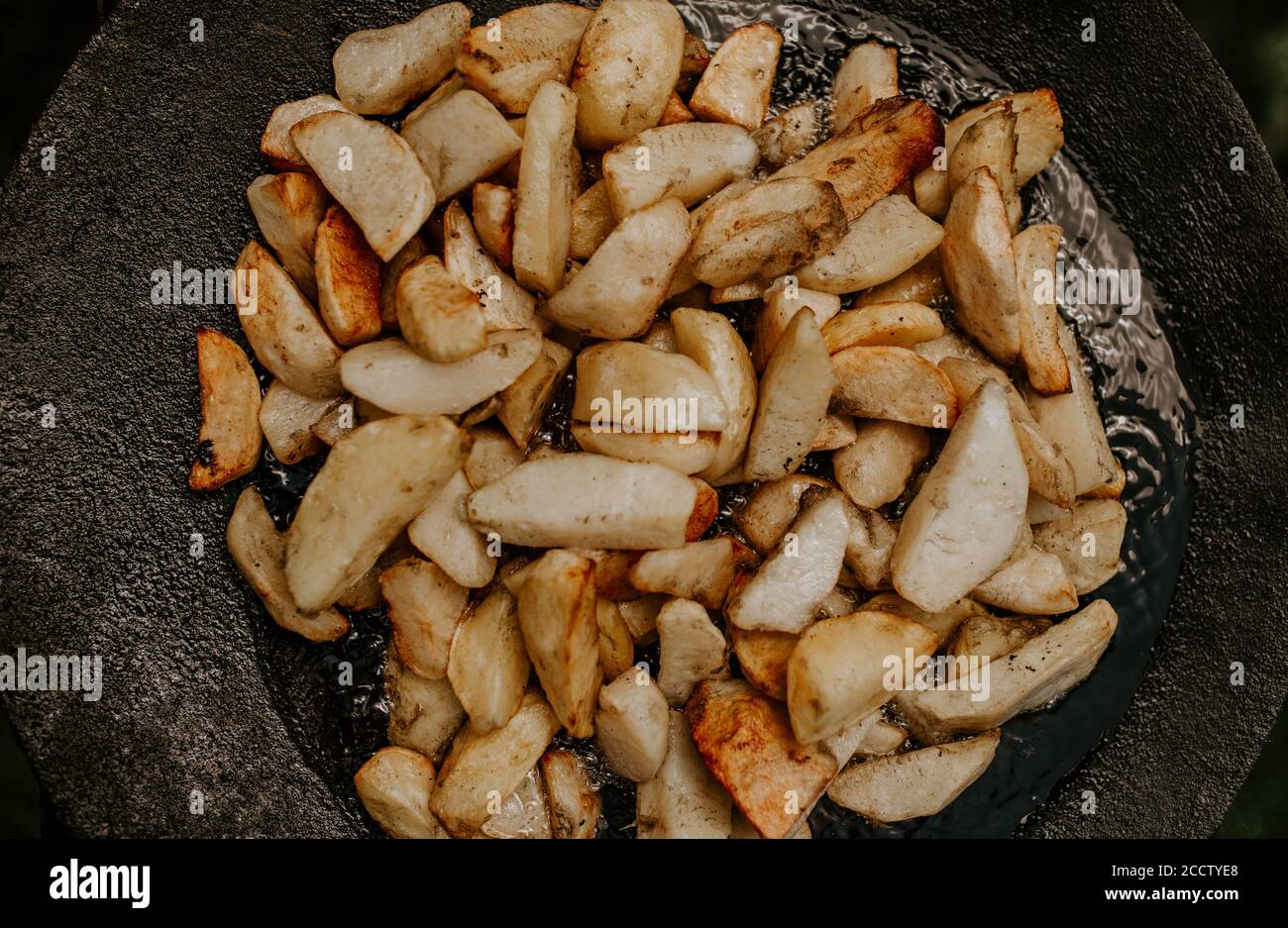 pommes de terre frites avec une croûte cuite dans un grand noir faites cuire sur le gril Banque D'Images