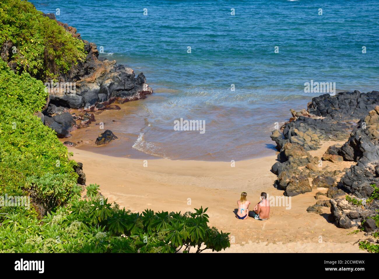 Un couple se détend dans un coin confortable de Wailea Beach, Maui, Hawaii, États-Unis Banque D'Images