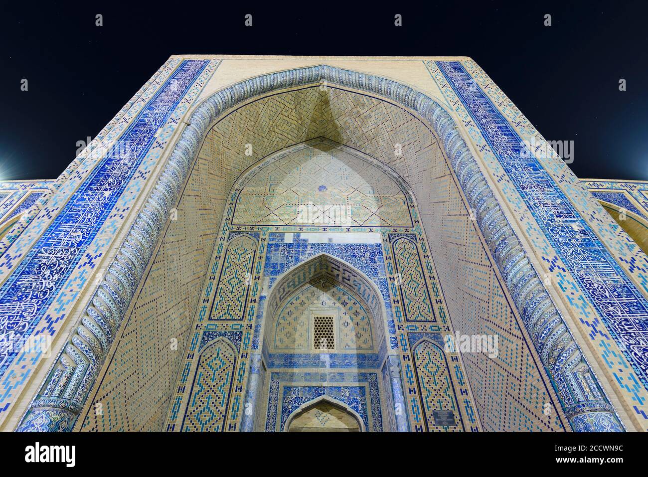 Iwan d'Ulugh supplie Madrasa à Boukhara, Ouzbékistan. Portail d'entrée du madrassa décoré de tuiles de majolica dans le pishtaq et de carreaux de céramique la nuit. Banque D'Images