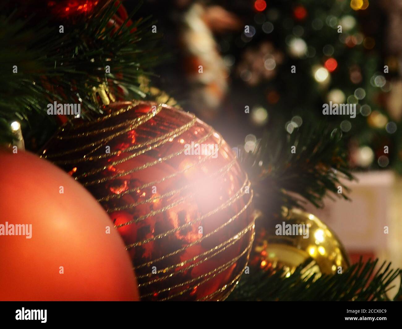 Gros plan d'une boule suspendue sur un arbre de Noël illuminé. Boules de  Noël et de bibelots comme un fond pour des cartes postales, beaucoup de  différents jouets de Noël dans Photo
