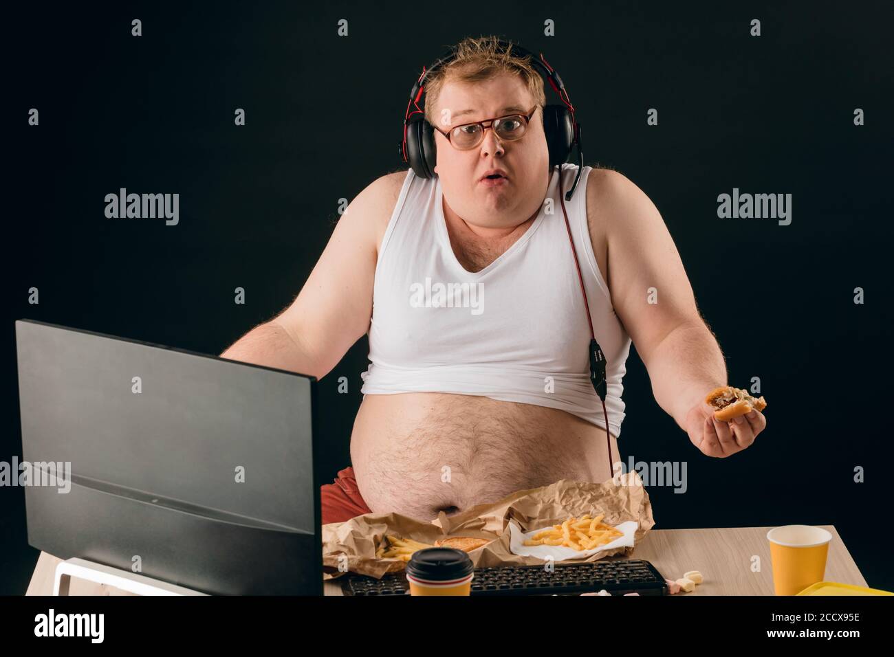 drôle de plump homme tenant un hamburger et regardant l'appareil photo avec l'expression étonnante . portrait de gros plan. Comment vous perdez du poids Pourquoi je suis fa Banque D'Images