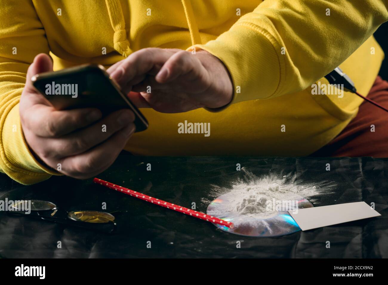 gros plan rogné photo. homme tenant un smartphone, l'utilisant, commerce illégal.le cracher de stupéfiants Banque D'Images