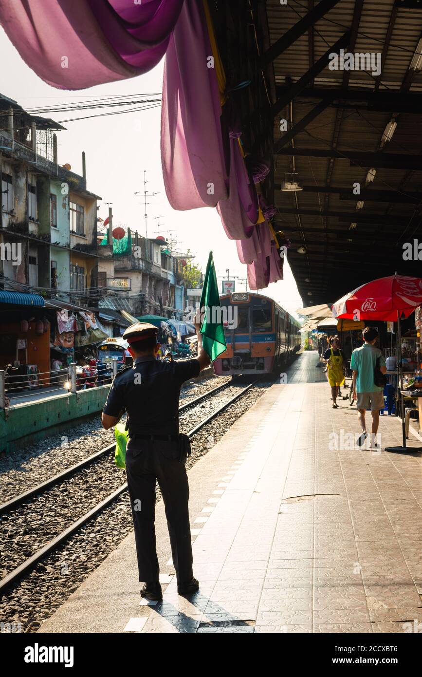 Conducteur avec drapeaux sur la plate-forme de la gare locale Dans le quartier Thon Buri de Bangkok Banque D'Images